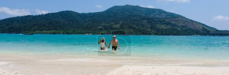Photo for Couple of men and women on the beach of Koh Lipe Island Thailand, a tropical Island with a blue ocean and white soft sand. Ko Lipe Island Thailand - Royalty Free Image