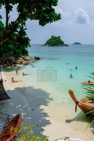 Téléchargez les photos : Koh Lipe Island Thaïlande Avril 2023, les gens se détendre dans l'océan sur une île tropicale avec un océan bleu et sable blanc doux. Ko Lipe Island Thaïlande - en image libre de droit