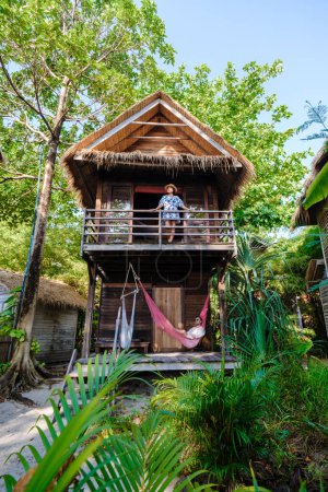 Foto de Pareja en un bungalow en la playa de una isla en Tailandia, villa de madera en la playa con palmeras, pareja de vacaciones en Tailandia - Imagen libre de derechos