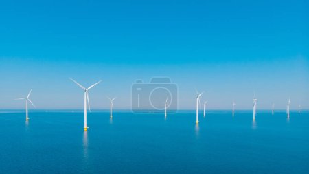 Photo for Windmill Park with a blue sky windmill turbines park in the ocean. Netherlands Europe the biggest wind park in the Netherlands Flevoland - Royalty Free Image