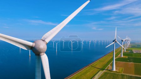 Photo for Windmill Park with a blue sky and green agricultural field, and windmill turbines park in the ocean. Netherlands Europe the biggest wind park in the Netherlands - Royalty Free Image
