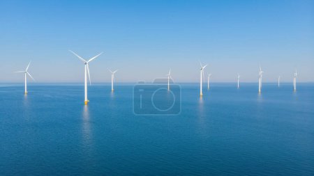 Foto de Parque de molinos de viento con un parque de turbinas de molino de viento cielo azul en el océano. Países Bajos Europa el parque eólico más grande de los Países Bajos en un día soleado - Imagen libre de derechos