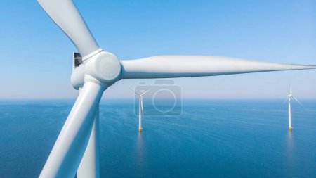 Foto de Parque de molinos de viento con un cielo azul cerca de las turbinas de molinos de viento en el mar - Imagen libre de derechos