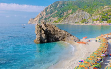 Téléchargez les photos : Plage de galets Vacances à Monterosso Cinque Terre Monterosso al Mare Chaises et parasols remplissent la plage Spiaggia di Fegina, Monterosso, partie des Cinque Terre Italie pendant les vacances d'été - en image libre de droit