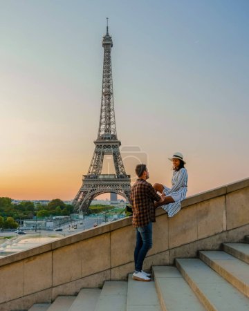 Téléchargez les photos : Jeune couple par Tour Eiffel à Sunrise, Paris Tour Eifel Sunrise homme femme amoureuse, concept valentin à Paris la ville de l'amour. Visiter la Tour Eiffel Paris France. - en image libre de droit