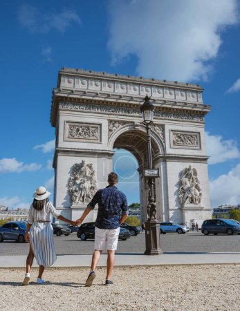 Téléchargez les photos : Couple en ville à Paris visitant Avenue des Champs Elysées Paris France Arc De Triomphe. Hommes et femmes visitant l'Arc de Triomphe à Paris en été - en image libre de droit