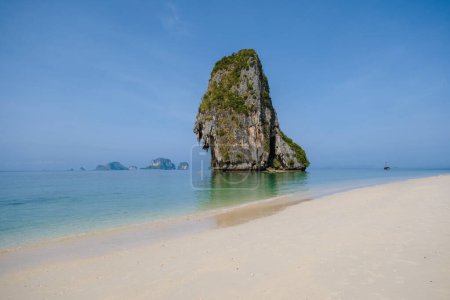 Téléchargez les photos : Railay Beach Krabi Thaïlande, la plage tropicale de Railay Krabi, vue panoramique sur la plage idyllique de Railay Beach en Thaïlande avec un bateau long traditionnel et un ciel nuageux - en image libre de droit
