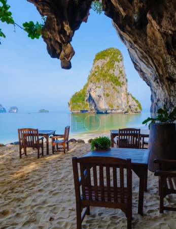 Foto de Restaurante con sillas en la playa en una gruta de piedra caliza acantilado en Railai Beach Krabi Tailandia. - Imagen libre de derechos