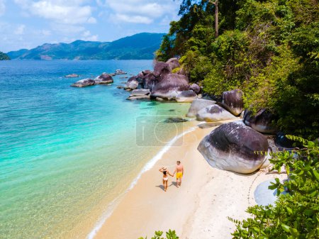 Téléchargez les photos : Koh Adang Island Thaïlande du Sud, un couple d'hommes et de femmes sur la plage avec une turqouse couleur océan pendant les vacances en Thaïlande - en image libre de droit