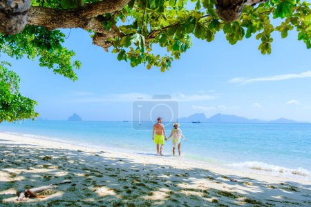 Téléchargez les photos : Koh Kradan Island Le sud de la Thaïlande a voté comme la nouvelle plage nr 1 dans le monde. un couple d'hommes et de femmes marchant sur la plage tropicale de Koh Kradan au bord de l'océan - en image libre de droit