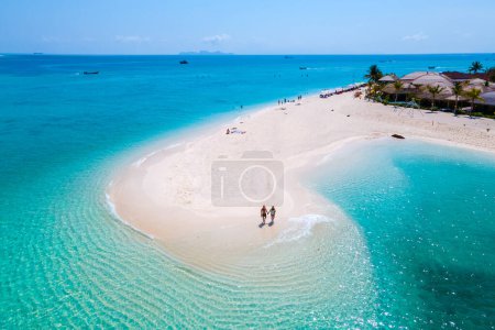 Photo for Men and women walking on a sandbar in the ocean of Koh Lipe Southern Thailand during vacation. - Royalty Free Image