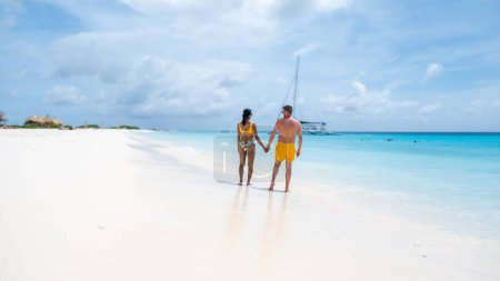 Klein Curacao Island with Tropical beach at the Caribbean island of Curacao Caribbean , a couple of men and women on a boat trip to Small Curacao Island with a white beach and turqouse colored ocean
