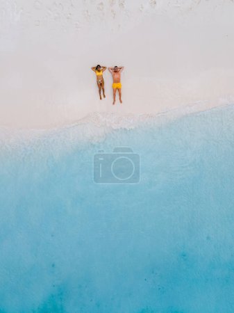 Drohnen-Luftaufnahme von Klein Curacao Insel mit tropischem Strand an der Karibik, von oben ein paar Männer und Frauen auf dem Liegen am Strand von Klein Curacao Insel