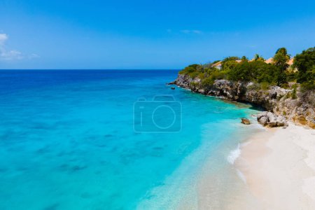 Photo for Playa Kalki Beach Caribbean island of Curacao, Playa Kalki in Curacao, white beach with a blue turqouse colored ocean. Drone aerial view above a beach with beach chairs and umbrellas - Royalty Free Image