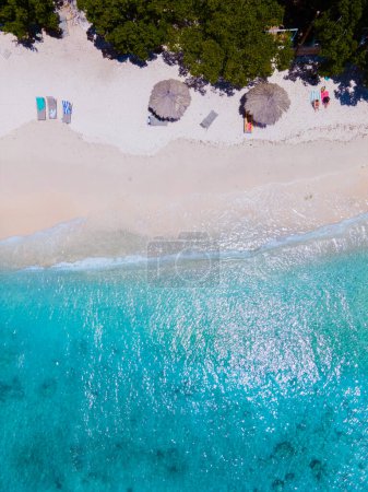 Foto de Playa Kalki Beach Isla caribeña de Curazao, Playa Kalki en Curazao, playa blanca con un océano azul turquesa. Drone vista aérea por encima de una playa con sillas de playa y sombrillas - Imagen libre de derechos