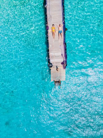 Foto de Playa Kalki Beach Isla caribeña de Curazao, playa blanca con un océano azul turquesa. Drone vista aérea de un par de hombres y mujeres en la playa - Imagen libre de derechos