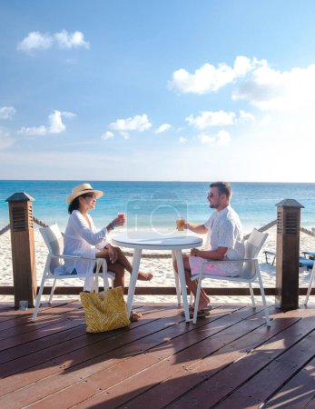 Téléchargez les photos : Resort de luxe avec piscine près de Palm Beach Aruba Caraïbes, couple homme et femme d'âge moyen en vacances de luxe dans les Caraïbes - en image libre de droit