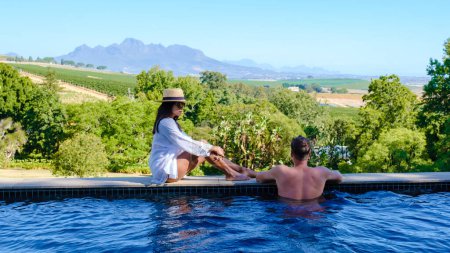 Foto de Un par de hombres y mujeres están de vacaciones en Sudáfrica en un paisaje de viñedo con montañas en Stellenbosch, cerca de Ciudad del Cabo, Sudáfrica - Imagen libre de derechos