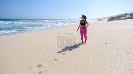 Photo for Asian women relaxing on the beach at De Hoop Nature Reserve South Africa Western Cape, the most beautiful beach in South Africa with the white dunes part of the garden route. - Royalty Free Image