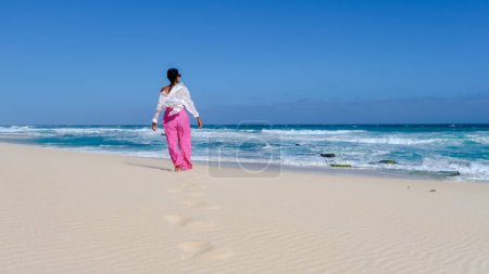 Téléchargez les photos : Femmes asiatiques se détendre sur la plage à la réserve naturelle De Hoop Afrique du Sud Cap occidental, la plus belle plage d'Afrique du Sud avec les dunes blanches partie de la route du jardin. - en image libre de droit