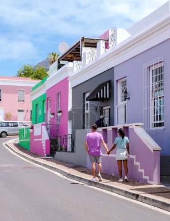 Téléchargez les photos : Bo Kaap Canton de rue coloré au Cap, est une rue colorée avec des maisons en Afrique du Sud. Bo Kaap ou ancien quartier de Malay Quarter, quelques hommes et femmes en voyage au Cap - en image libre de droit