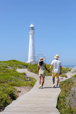 Téléchargez les photos : Couple hommes et femmes visitant le phare de Slangkop Kommetjie Le Cap Afrique du Sud, Le phare de Slangkop dans le village de Kommetjie sur la péninsule du Cap. - en image libre de droit