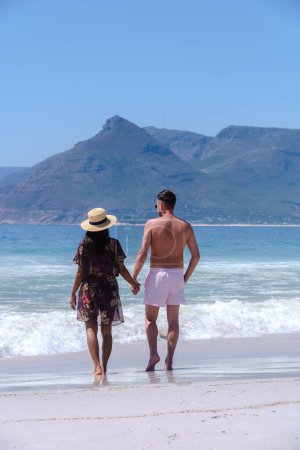 Foto de Kommetjie Public Beach Cape Town South Africa, white beach and blue ocean at Kommetjie on a summer day, couple man and woman walking at the beach in Cape Town South Africa - Imagen libre de derechos