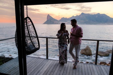 Photo for Couple man and women watching sunset on the balcony at vacation in Cape Town South Africa. - Royalty Free Image