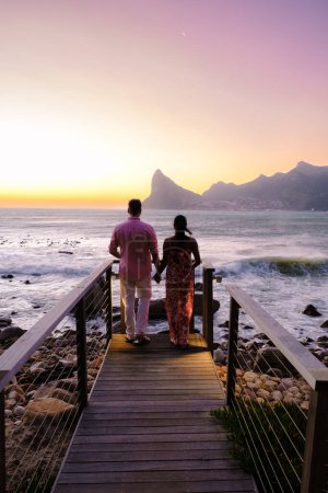Téléchargez les photos : Couple homme et femmes regardant le coucher du soleil sur le balcon pendant les vacances Cape Town Afrique du Sud. - en image libre de droit