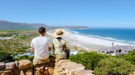 Téléchargez les photos : Belle plage de sable blanc Noordhoek le long de Chapmans pic conduire Le Cap Afrique du Sud. Noordhoek Beach Cape Town. Homme et femme au bord d'une plage - en image libre de droit