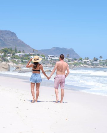 Photo for Couple of men and women at the beach of Camps Bay Cape Town , Camps Bay beach drone aerial view during summer in Cape Town Sout Africa, drone view at the beach during summer - Royalty Free Image