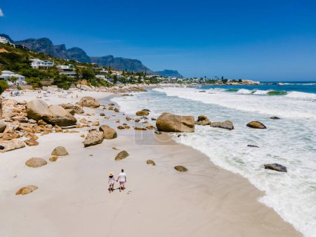 Foto de Pareja de hombres y mujeres en la playa de Camps Bay Cape Town, Camps Bay vista aérea de la playa durante el verano en Ciudad del Cabo Sout Africa, - Imagen libre de derechos