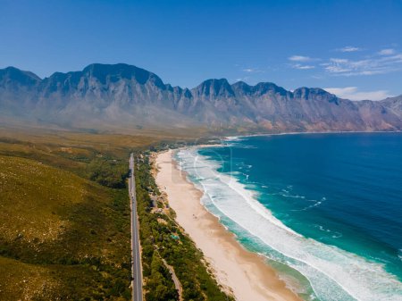 Téléchargez les photos : Kogelbay Beach Western Cape Afrique du Sud, Kogelbay Rugged Coast Line avec des montagnes spectaculaires. Route du jardin. Drone vue aérienne sur une route dans les montagnes à côté de l'océan - en image libre de droit