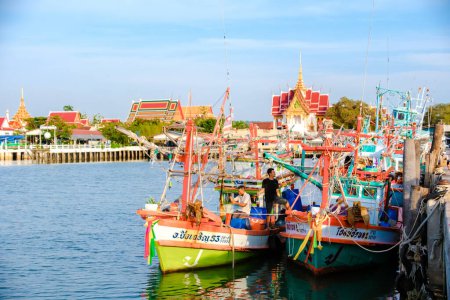 Téléchargez les photos : Bangsaray Pattaya Thaïlande Mai 2023, le port de pêche du village de pêcheurs Bangsaray au coucher du soleil avec des bateaux de pêche en bois colorés - en image libre de droit