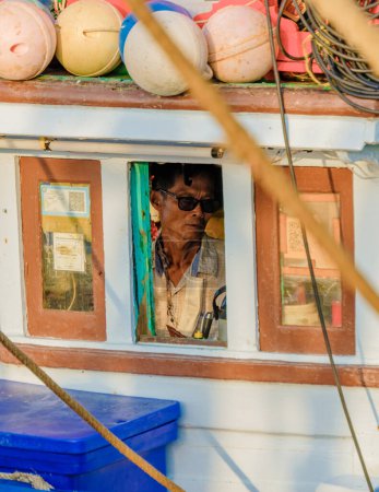 Photo for Bangsaray Pattaya Thailand May 2023, the captain of a fishing boat at the fishing harbor at the fishing village Bangsaray. - Royalty Free Image