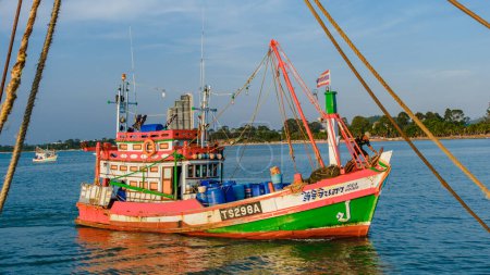 Téléchargez les photos : Bangsaray Pattaya Thaïlande Mai 2023, port de pêche au village de pêcheurs Bangsaray au coucher du soleil avec des bateaux de pêche en bois colorés au crépuscule - en image libre de droit