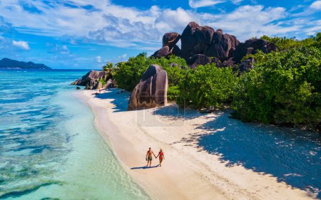 Anse Source dArgent, La Digue Seychellen, ein junges Paar an einem tropischen Strand während eines Luxusurlaubs auf den Seychellen. Tropischer Strand Anse Source dArgent, La Digue Seychellen