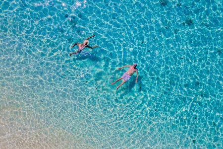 Photo for Drone view of a men and woman swimming in the blue turqouse colored ocean of Koh Kradan island in Thailand - Royalty Free Image