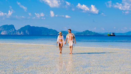 Téléchargez les photos : Un couple d'hommes et de femmes sur la plage de l'île de Koh Kradan Thaïlande, hommes et femmes se détendre sur la plage avec une turque couleur océan par une journée ensoleillée - en image libre de droit