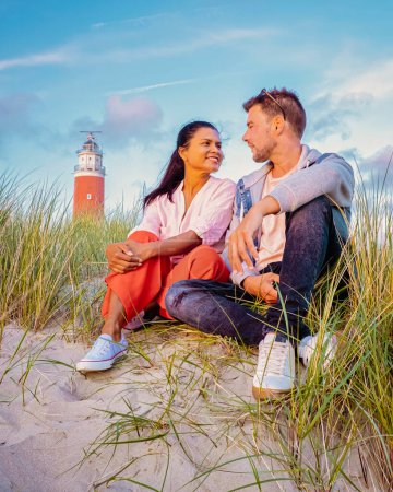 Téléchargez les photos : Phare Texel pendant le coucher du soleil Pays-Bas Île hollandaise Texel Hollande, le couple visite le phare, hommes et femmes en vacances Texel - en image libre de droit