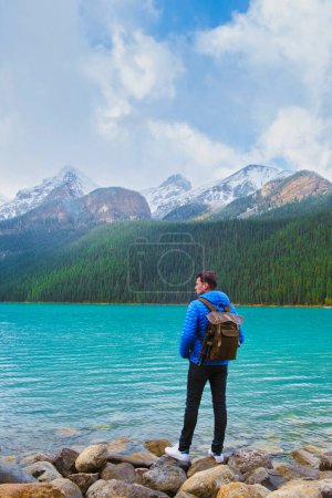 Téléchargez les photos : Lake Louise Banff national park is a lake in the Canadian Rocky Mountains. Young men visiting Lake Louise during a vacation in Canada - en image libre de droit