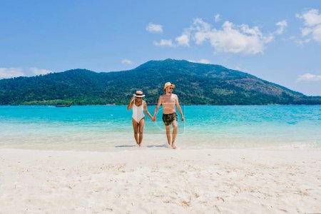 Ein Paar Männer und Frauen am Strand von Koh Lipe Island Thailand, einer tropischen Insel mit blauem Meer und weichem Sand. Ko Lipe Island Thailand
