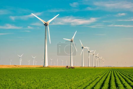 Foto de Parque de molinos de viento con un cielo azul y campo agrícola verde, y parque de turbinas de molinos de viento en los Países Bajos Europa es el parque eólico más grande de los Países Bajos - Imagen libre de derechos