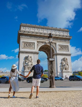 Téléchargez les photos : Couple en ville à Paris visitant Avenue des Champs Elysées Paris France Arc De Triomphe. Hommes et femmes visitant l'Arc de Triomphe à Paris en été - en image libre de droit