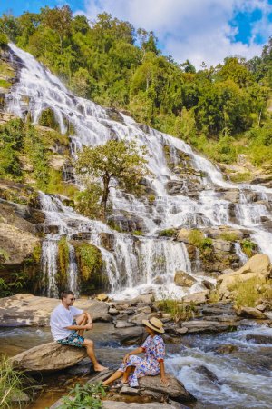 Photo for Mae Ya Waterfall Doi Inthanon national park Thailand Chiang Mai is a beautiful waterfall in Doi Inthanon national park in Thailand. A couple of men and a woman visiting a waterfall in Thailand - Royalty Free Image