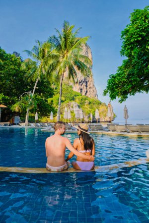 Foto de Pareja de hombres y mujeres en una piscina en un complejo de lujo en Tailandia durante sus vacaciones en Krabi - Imagen libre de derechos