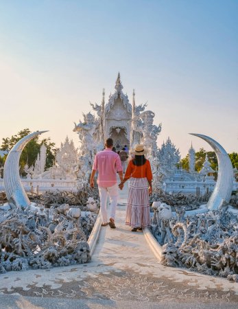 Photo for Couple of men and women visiting the white temple in Chiang Rai during sunset in Thailand - Royalty Free Image
