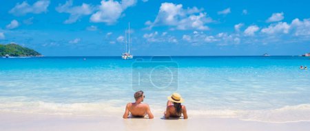 Téléchargez les photos : Anse Lazio Praslin Seychelles, un jeune couple d'hommes et de femmes sur une plage tropicale pendant des vacances de luxe aux Seychelles. Plage tropicale Anse Lazio Praslin Seychelles - en image libre de droit