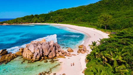 Photo for Anse Cocos La Digue Seychelles, a young couple of men and women on a tropical beach during a luxury vacation in Seychelles. Tropical beach Anse Cocos La Digue Seychelles. - Royalty Free Image