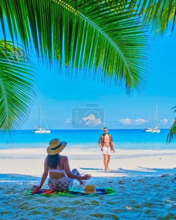 Foto de Anse Lazio Praslin Seychelles, una joven pareja de hombres y mujeres en una playa tropical durante unas vacaciones de lujo en Seychelles. Playa tropical Anse Lazio Praslin Seychelles - Imagen libre de derechos
